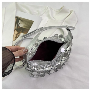 Detailed view of silver sequin handbag showing deep red lining and interior space