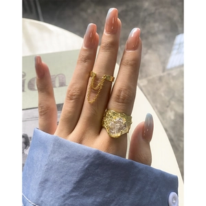 Unregelmäßiger Silberring mit transparentem Stein und goldenem Kettendesign