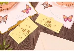 Close-up of 3D butterfly birthday card set with cake print on wooden background
