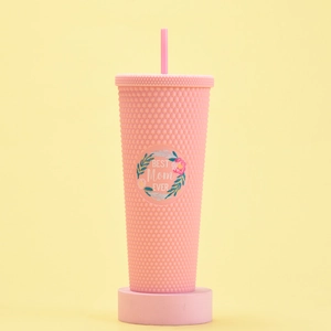 Detailed view of pink textured tumbler with Best Mom Ever sticker on yellow backdrop