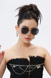 Close-up of golden metal frame sunglasses with oversized dark lenses on model face