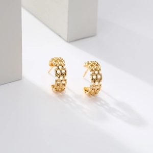 Macro shot of S925 sterling silver stamp on golden braided chain C-shaped hoop earrings