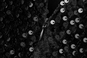 Détail de paillettes noires scintillantes et fermeture éclair en métal sur la robe