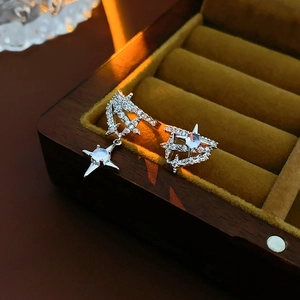 Macro view of silver starburst ear cuff with zircon and moonstone on yellow velvet