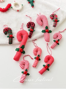 Detail view of plaid and polka dot fabric candy cane ornaments with holly berry accents