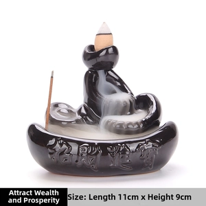 Detail of backflow incense burner showing white smoke waterfall and gold calligraphy