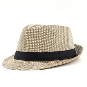 Macro detail of breathable straw weave and black grosgrain ribbon on the fedora hat
