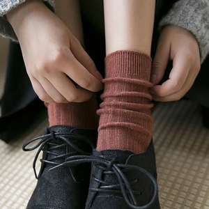 Detail of caramel cotton knit mid-calf socks with ribbed texture and vintage style
