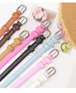Flat lay view of various colorful slim PU leather belts with silver metal buckles