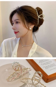 Close-up of elegant flower hair claw clip paired with pearl earrings and necklace