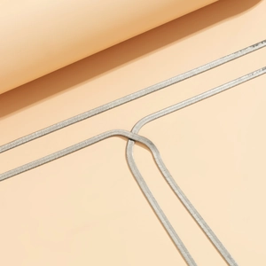 Nahaufnahme der eleganten silbernen Schlangenkette mit glatter Metalloberfläche auf Beige