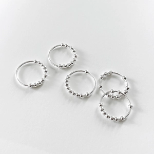 Set of five silver fidget rings with moving beads on a clean white background