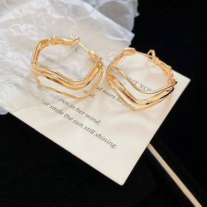 Close-up of gold layered hoop earrings on decorative card in a black velvet jewelry box