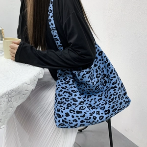Detail of blue leopard print corduroy tote bag showing large capacity worn by model