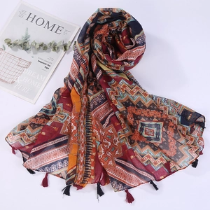 Detailed view of bohemian style shawl with colorful geometric patterns and red fringe