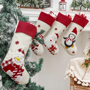 Set of four Christmas stockings with Santa and snowman on fireplace mantel