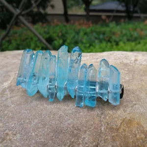 Detail of blue crystal hair clip with silver wire wrapping on natural stone background