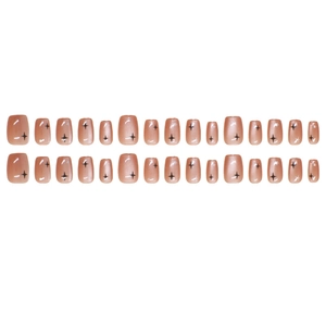 Cat-eye press-on nails set with black starburst patterns on nude pink short square nails
