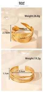 Detail view of two gold adjustable open bangles with feather texture and multi-line design