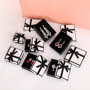 Elegant white jewelry boxes with black ribbons and inner foam padding for rings