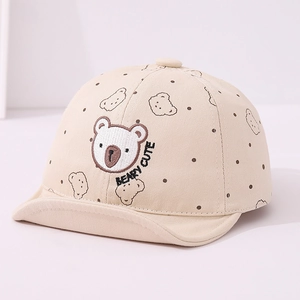 Dettaglio del cappellino per neonati in cotone con ricamo orso e pois marroni