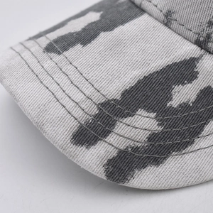 Gros plan sur la visière d'une casquette en denim avec coutures renforcées et motif dégradé