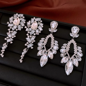 Close-up of hollow teardrop earrings with crystals on a black jewelry tray