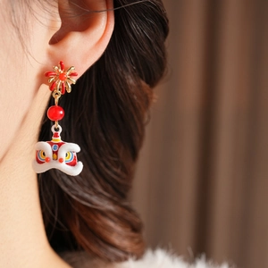 Detailed close-up of a festive Chinese lion dance earring with white flocking texture