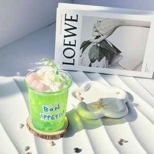 Green summer drink scented jelly candle with cream topping on a wooden base