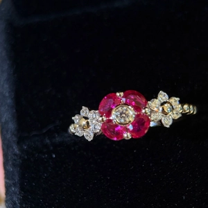 Vintage gold ring with red ruby flower and diamond accents on black velvet