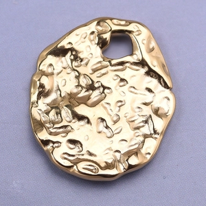 Macro shot of irregular 304 stainless steel golden oval pendant with hammered texture