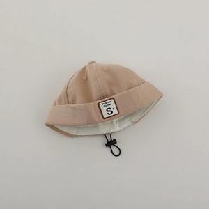 Dettaglio del cappello docker beige in cotone con coulisse regolabile ed etichetta S