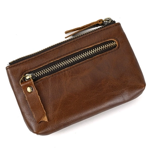 Detailed view of dark brown genuine leather coin purse with metal zippers and textured surface