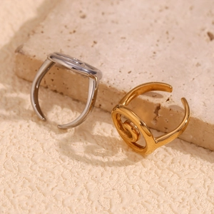 Elegant spiral swirl open rings in gold and silver finish on textured stone