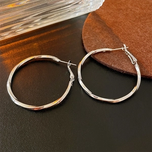 Silver twisted geometric hoop earrings with polished metal finish in minimalist style