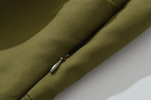 Detailaufnahme von olivgrünem Köperstoff mit einem hochwertigen, nahtlosen Reißverschluss