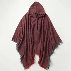 Detail of red and grey knit hooded poncho with bohemian fringed edges on white background