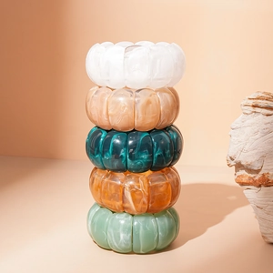 Detailed stack of multi-row acrylic geometric bracelets with marble textures and amber tones