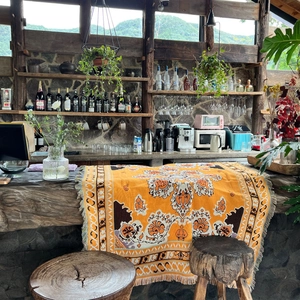 Detail of bohemian orange woven blanket with tassels on a wooden bar counter