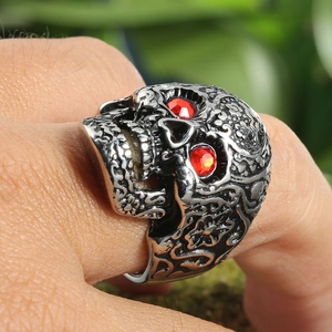 Macro shot of vintage skull ring featuring detailed red gemstone eyes and silver finish