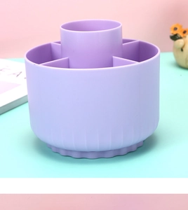 Close-up of a purple rotating desk organizer with multiple compartments for pens and brushes