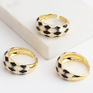Adjustable gold open ring featuring black and white enamel checkerboard pattern