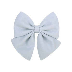 Détail montrant la texture du tissu bleu clair et les couches de la pince à cheveux