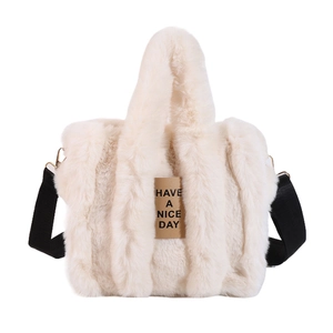 Detailed close-up of cream faux fur tote bag with Have a Nice Day leather patch