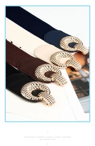 Detail of four elastic waist belts with textured golden round buckles in multiple colors