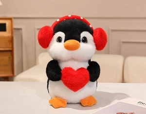 Detailed close-up of soft plush penguin toy with heart and polka dot earmuffs