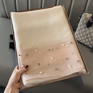 Detail of cream and nude pink silk scarf featuring pearl beads and shiny silk accents