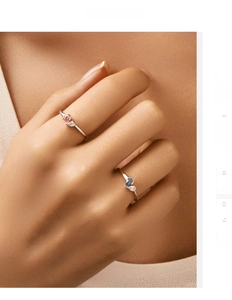 Detail of minimalist S925 silver rings with teardrop pink and blue stones on finger