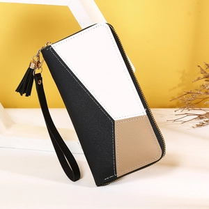 Detalle de cartera de cuero tricolor con cremallera y colgante decorativo de borla negra