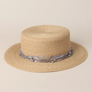 Detailed view of raffia straw boater hat with grey organza ribbon and pearl accents
